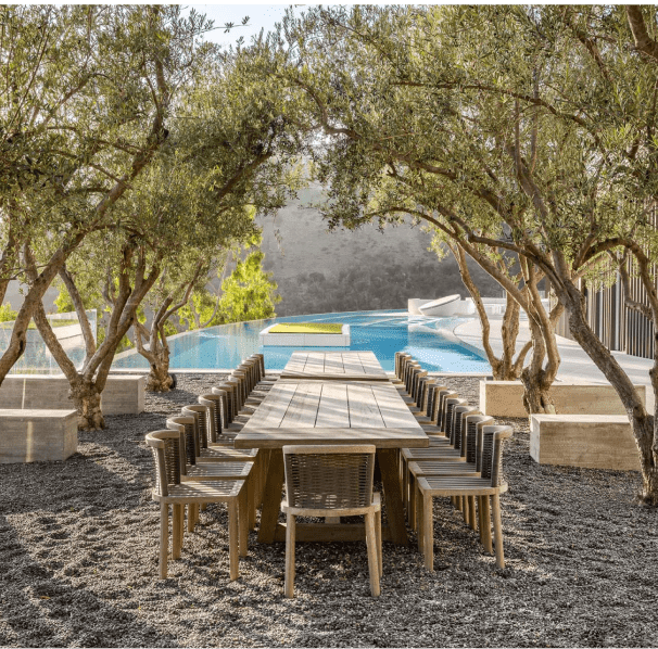 Table and chairs set in front of an infinity pool.
